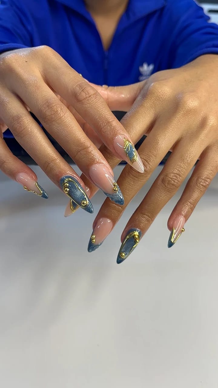 Almond nails in denim blue with gold chrome accents